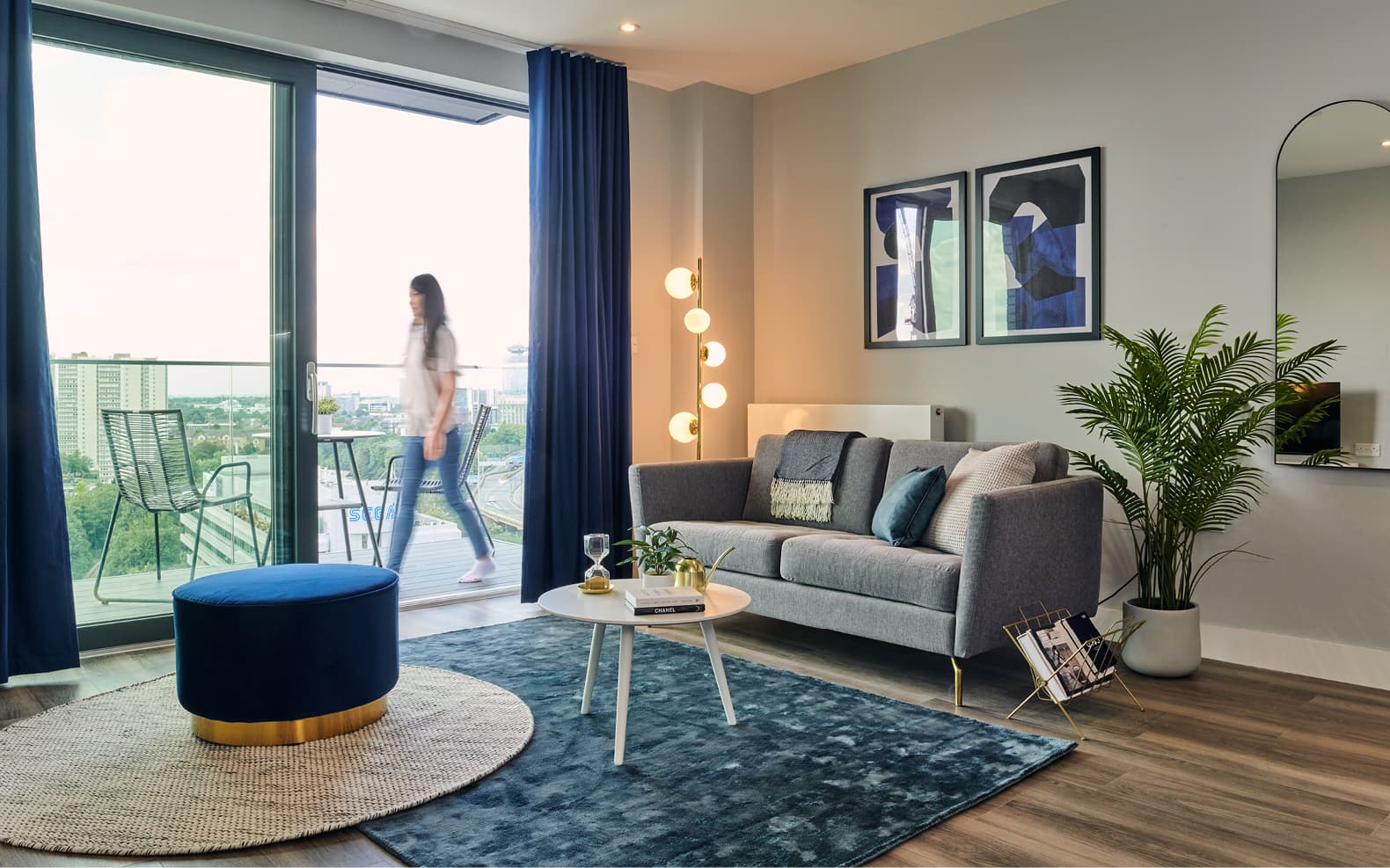 lounnge with sofa and chairs with view of girl walking on balcony