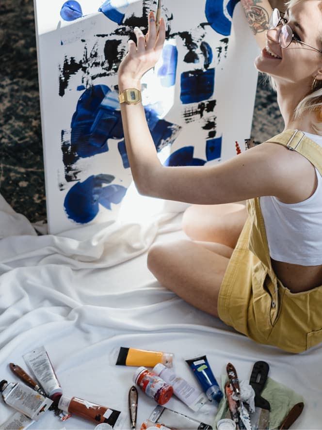 Person sat down on floor painting a picture