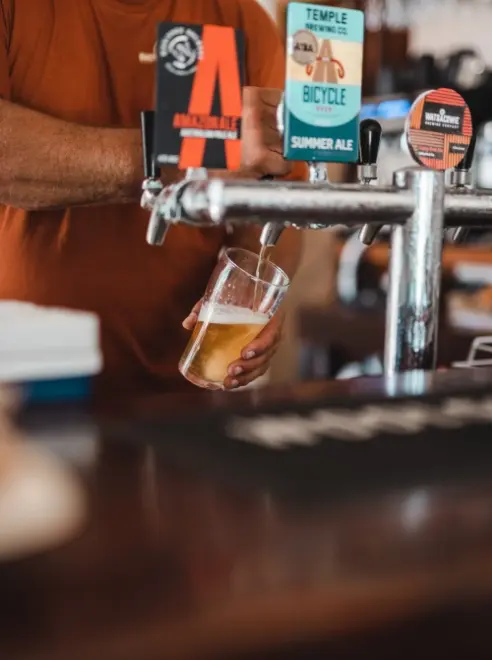 bar with beer taps and a pint being poured