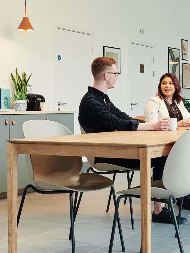 two people sat at table chatting