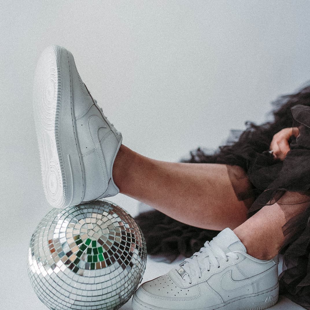 foot resting on glitter ball placed on floor