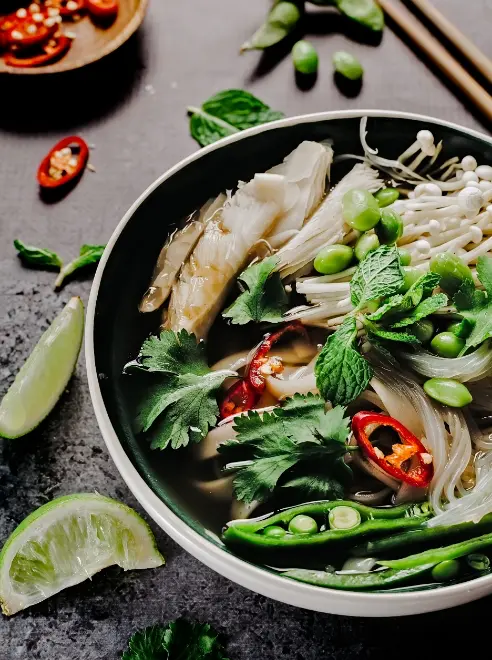 a bowel of Thai food with lime wedge and chillies