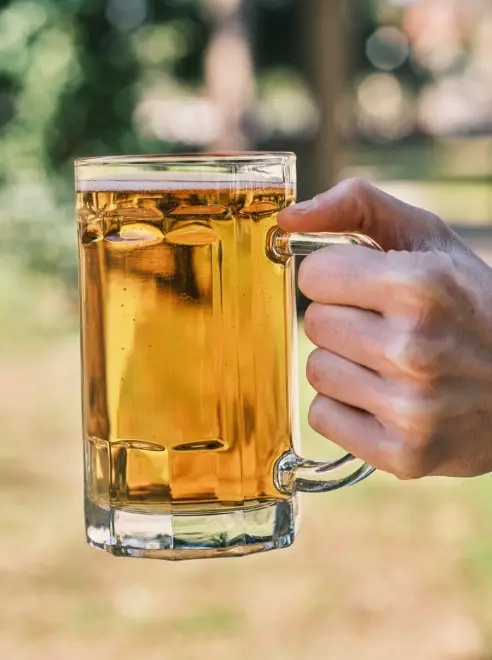 a full jug of lager being held