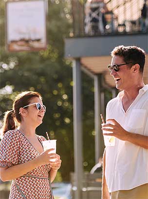 two people having a drink in the sun outside a pub