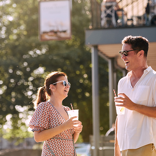 two people having a drink in the sun outside a pub