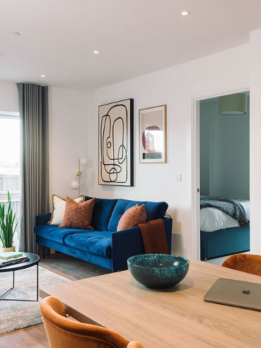 lounge with two seater sofa with doorway open to bedroom